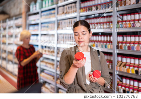 Woman buys jars of paint and glaze to coat pottery at a ceramic specialty store Woman buys jars of paint and glaze to coat pottery at a ceramic specialty store 102270768