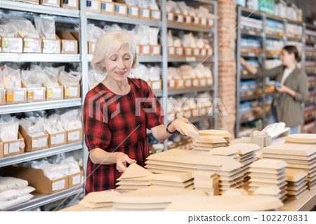 Elderly woman chooses blanks for making pottery 102270831