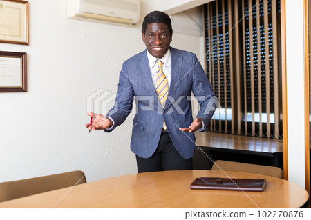 African american entrepreneur inviting to negotiations in meeting room African american entrepreneur inviting to negotiations in meeting room 102270876