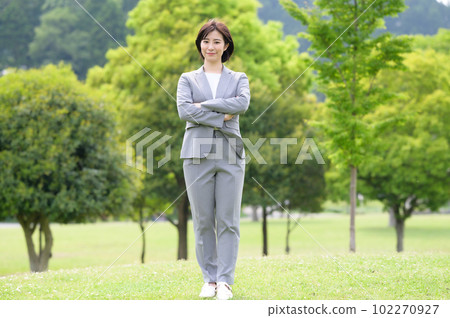 站在綠色背景下的西裝女性 站在綠色背景下的西裝女性 102270927