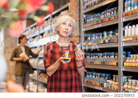 Elderly woman chooses acrylic lacquer for her future earthenware or ceramic dishes in specialty store 102270955