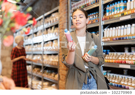 Female customer chooses multi-colored pigments for her future earthenware or ceramic tableware in specialty store 102270969