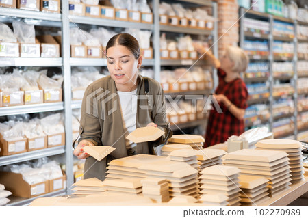 Young woman chooses blanks for making pottery 102270989