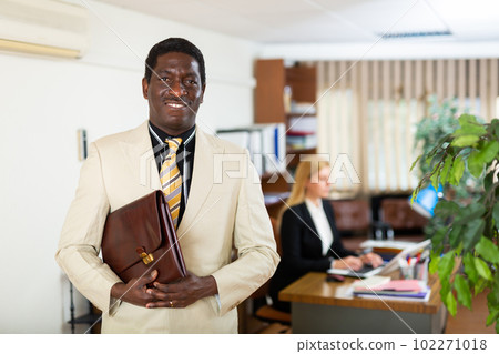 African american man in light business suit with portfolio in office African american man in light business suit with portfolio in office 102271018