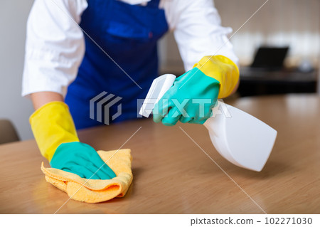 Worker cleaning table with rag and detergent 102271030