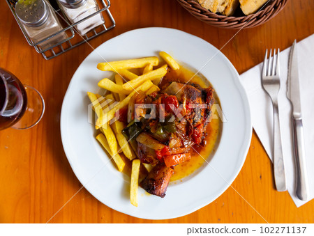 Baked pork shank with vegetables and french fries 102271137