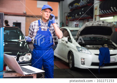 Car mechanic calls on smartphone to client Car mechanic calls on smartphone to client 102271153