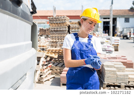 Female worker beside truck in warehouse Female worker beside truck in warehouse 102271182