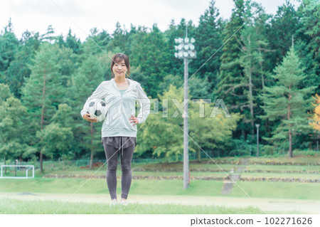 A Japanese woman who is a soccer fan and supporter with a soccer ball on the playground A Japanese woman who is a soccer fan and supporter with a soccer ball on the playground 102271626