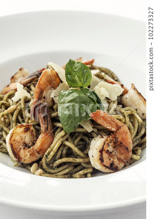 Spaghetti gamberi pasta with prawns and pesto on white background Spaghetti gamberi pasta with prawns and pesto on white background 102273327