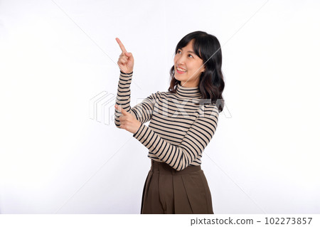 Beautiful young Asian woman on sweater cloth pointing up to copy space and looking at camera with smile face and happy isolated on white background 102273857