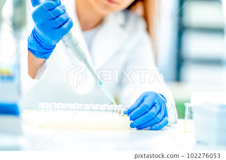pipetting of chemical samples during research in a biochemical scientific laboratory pipetting of chemical samples during research in a biochemical scientific laboratory 102276053
