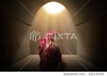 Muslim man with a beard wearing keffiyeh with agal in praying position (salat) on the prayer rug 102276303