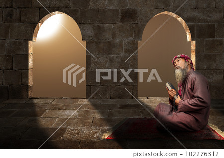 Muslim man with a beard wearing keffiyeh with agal holding Quran and prayer beads in his hands Muslim man with a beard wearing keffiyeh with agal holding Quran and prayer beads in his hands 102276312