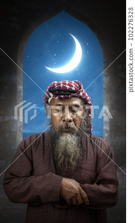 Muslim man with a beard wearing keffiyeh with agal in praying position (salat) on the prayer rug 102276328