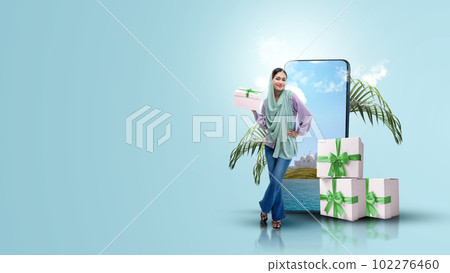 Asian Muslim woman in a headscarf holding a gift box 102276460