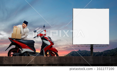 Asian Muslim man tying box on motorcycle prepare for mudik 102277100