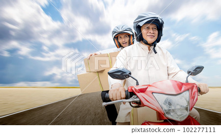 Asian Muslim family carrying a box on a motorcycle going mudik 102277111