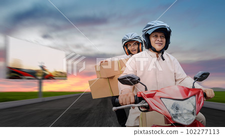 Asian Muslim family carrying a box on a motorcycle going mudik Asian Muslim family carrying a box on a motorcycle going mudik 102277113