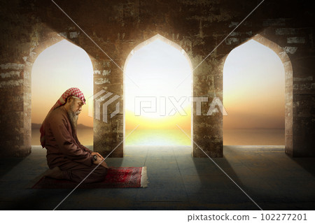 Muslim man with a beard wearing keffiyeh with agal in praying position (salat) on the prayer rug Muslim man with a beard wearing keffiyeh with agal in praying position (salat) on the prayer rug 102277201