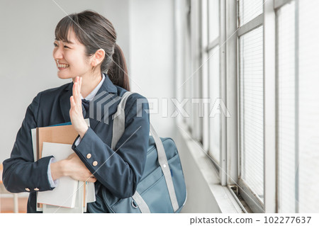 亞洲女學生在學校教室裡向她的朋友揮手 亞洲女學生在學校教室裡向她的朋友揮手 102277637