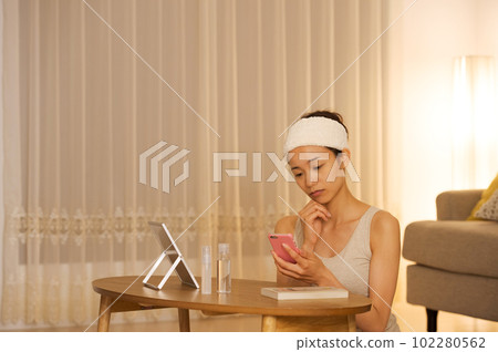 一個女人看著智能手機的肖像 一個女人看著智能手機的肖像 102280562