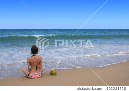 Sexy bikini body woman sitting on a beautiful beach and coconut on travel vacation. Banner crop for copy space. 102281518