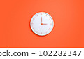 Clock on wall. White wall clock isolated on orange background.  102282347