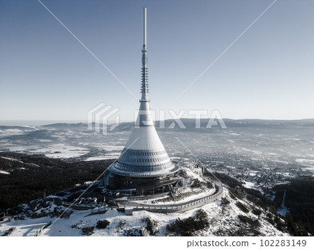 Jested mountain with modern hotel and TV transmitter on the top, Liberec, Czech Republic. Sunny winter day with snowy landscape. Aerial view from drone. Black and white photography. Jested mountain with modern hotel and TV transmitter on the top, Liberec, Czech Republic. Sunny winter day with snowy landscape. Aerial view from drone. Black and white photography. 102283149