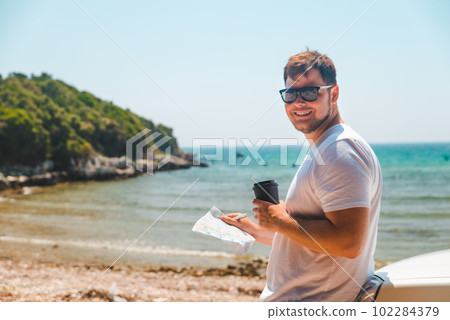 man checking on map at car hood destination place sea beach on background 102284379
