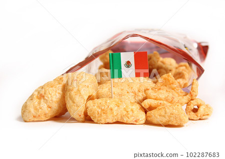 Open Bag of Pork Skins on Table With Flag of Mexico Open Bag of Pork Skins on Table With Flag of Mexico 102287683
