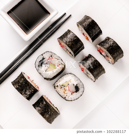 Sushi plate on white background, rolls set with vegetables on white background from above. Top view of traditional japanese cuisine. Asian food with chopsticks design. 102288117