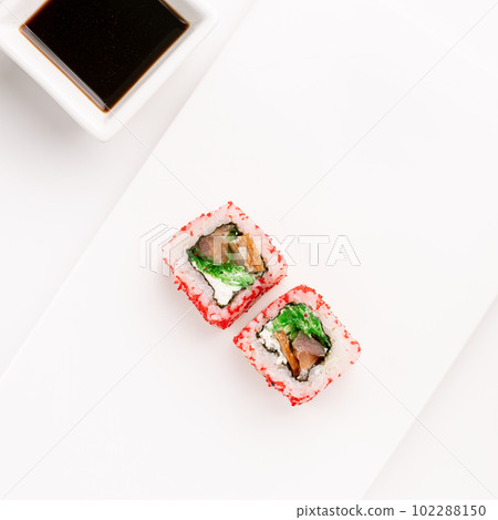 Sushi plate on white background, rolls set with red tobiko egg on white background from above. Top view of traditional japanese cuisine. Asian food with chopsticks design. 102288150