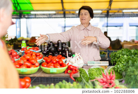 Aged woman customer buying vegetables in open-air market Aged woman customer buying vegetables in open-air market 102288806
