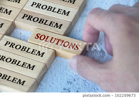 Hand placing wooden blocks with solutions text text on wooden blocks. Solutions to problems concept Hand placing wooden blocks with solutions text text on wooden blocks. Solutions to problems concept 102289673
