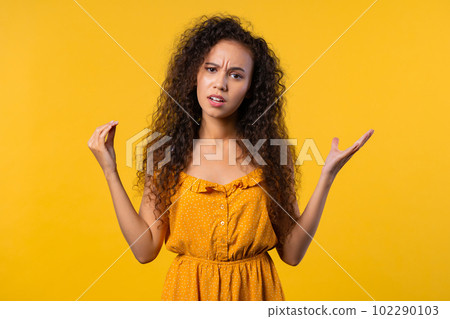 Irritated woman showing bla-bla-bla gesture with hands, rolling eyes on yellow. Irritated woman showing bla-bla-bla gesture with hands, rolling eyes on yellow. 102290103