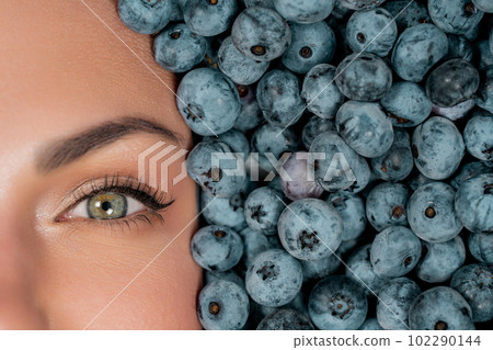 Half woman face in fresh ripe berries - blueberries, organic bilberry plant Half woman face in fresh ripe berries - blueberries, organic bilberry plant 102290144