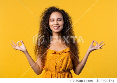 Calm woman relaxing, meditating, refuses stress. Sunny girl breathes deeply 102290175