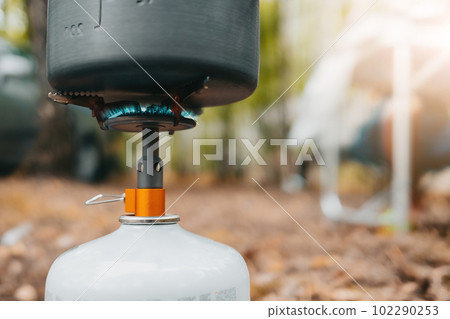Cooking on portable gas burner. Pan or kettle on camping stove.Bushcraft concept Cooking on portable gas burner. Pan or kettle on camping stove.Bushcraft concept 102290253