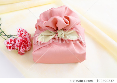 Gifts and flowers wrapped in a pink wrapping cloth Gifts and flowers wrapped in a pink wrapping cloth 102290832