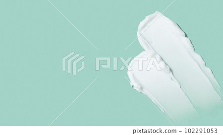 Beauty skincare cream texture swipe swatch. White beauty cream smear smudge isolated on green background Beauty skincare cream texture swipe swatch. White beauty cream smear smudge isolated on green background 102291053