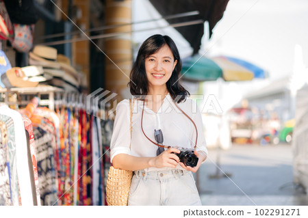 Portrait young beautiful woman with camera explore street in Bangkok, Thailand 102291271