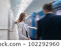 young woman in protective mask standing at subway station. 102292960