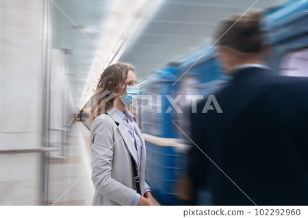 young woman in protective mask standing at subway station. young woman in protective mask standing at subway station. 102292960