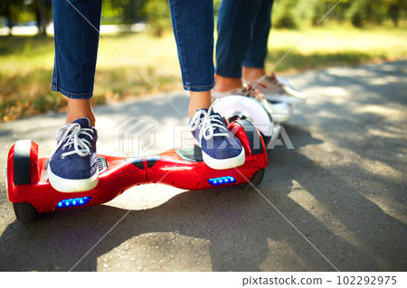 Young man and woman riding on the Hoverboard in the park. content technologies. a new movement. 102292975