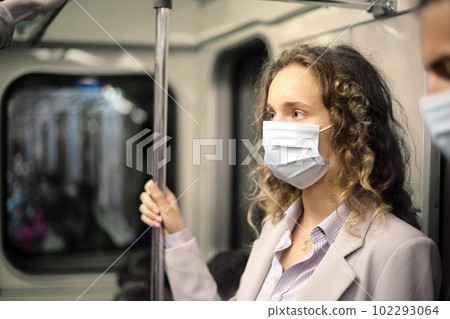 young woman in a protective mask standing in the subway car. 102293064