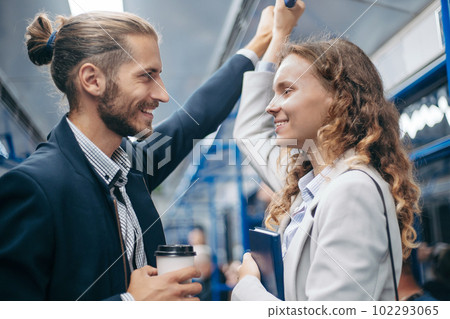 man and woman in love looking at each other on a subway train. 102293065