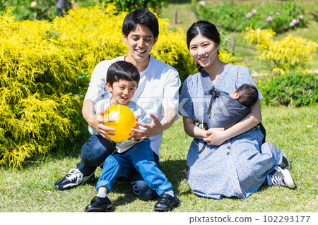 Child playing ball with family in park 102293177