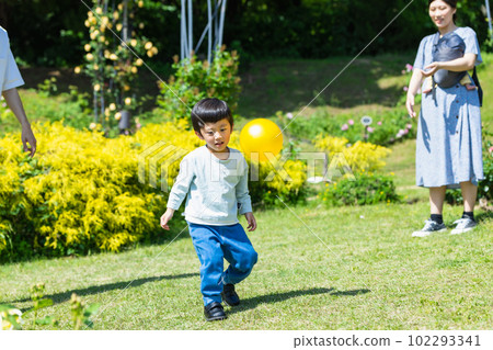 Child playing ball with family in park Child playing ball with family in park 102293341