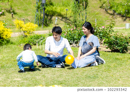 Child playing ball with family in park Child playing ball with family in park 102293342
